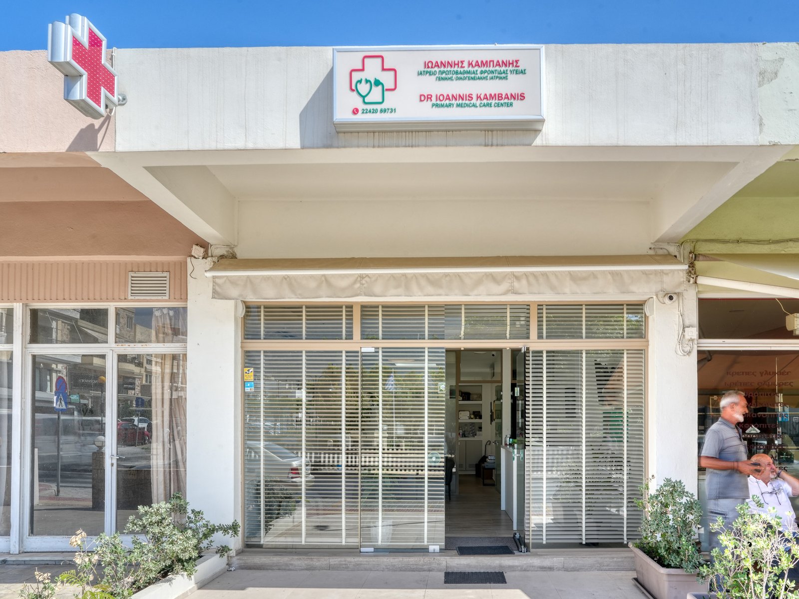 Street entrance of Dr. Ioannis Kambanis' medical practice in Zipari, Kos, with the green medical cross sign
